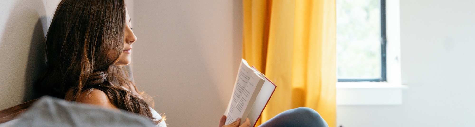 Woman reading book in her bedroom