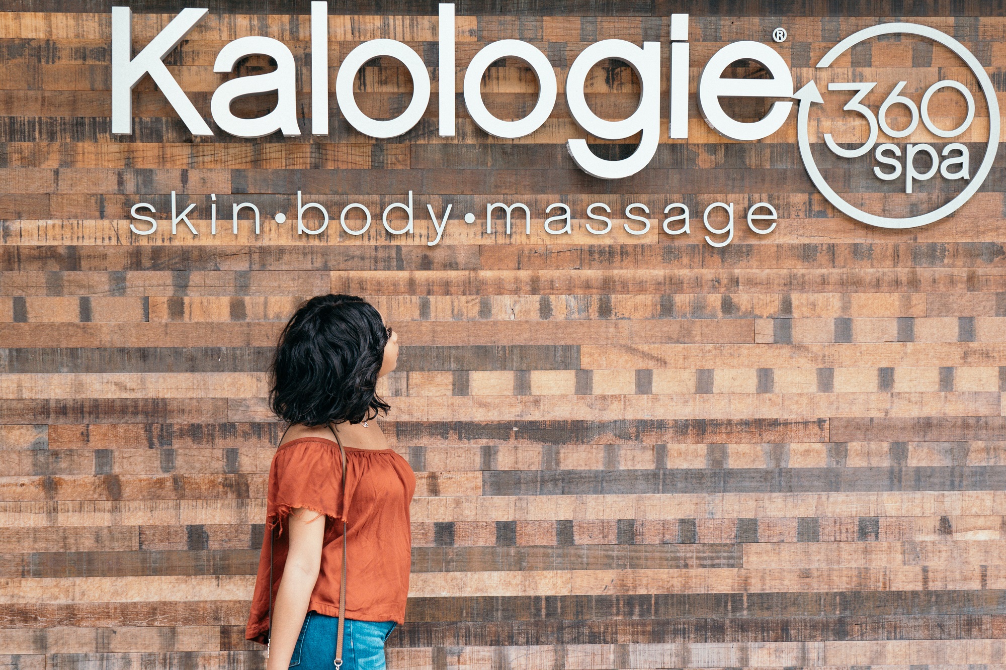 Woman looking at sign for Kalologie 360 Spa store