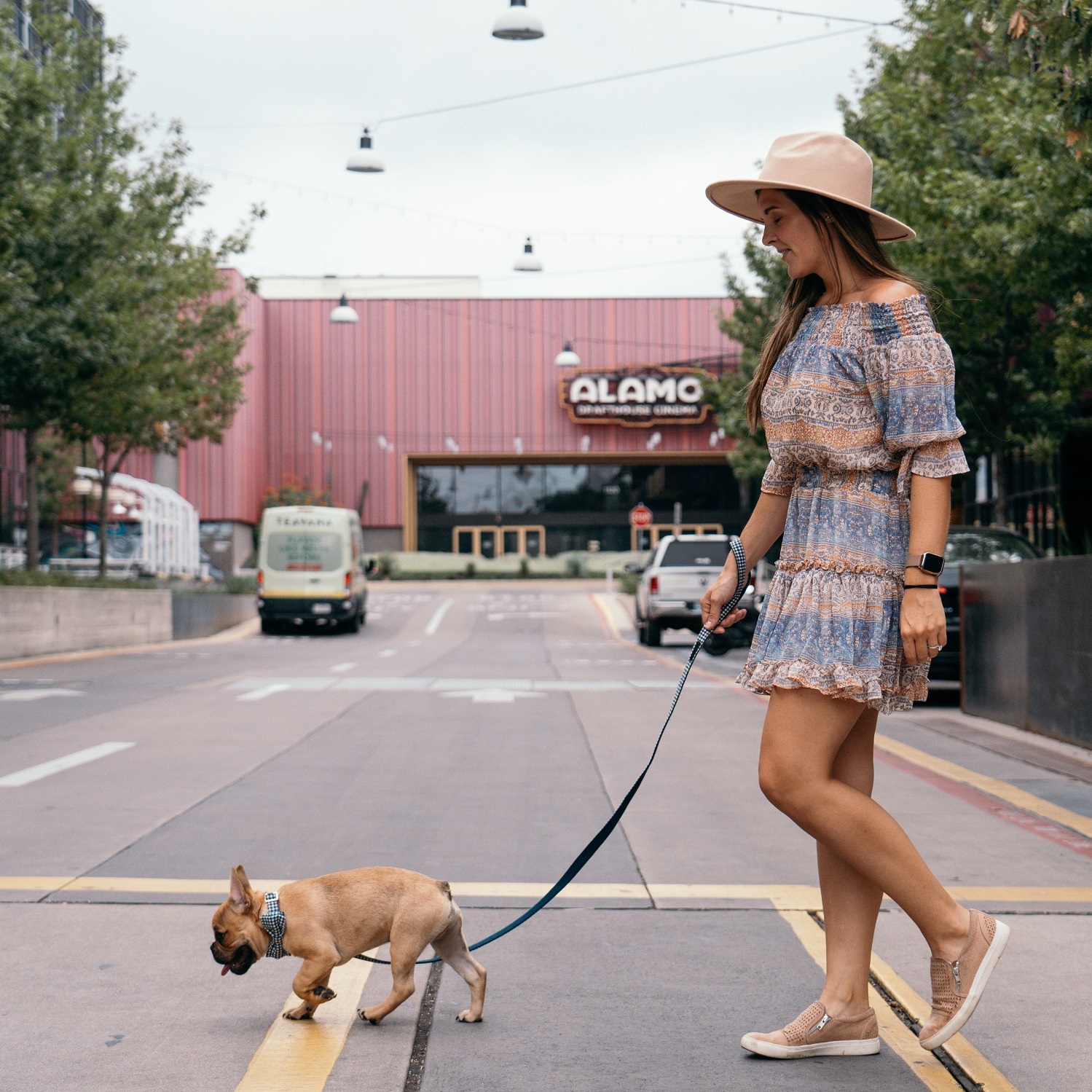Woman walking dog outside of Alamo Drafthouse